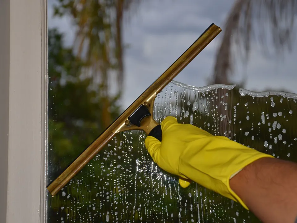 Raam wordt met een wisser streeploos schoongemaakt